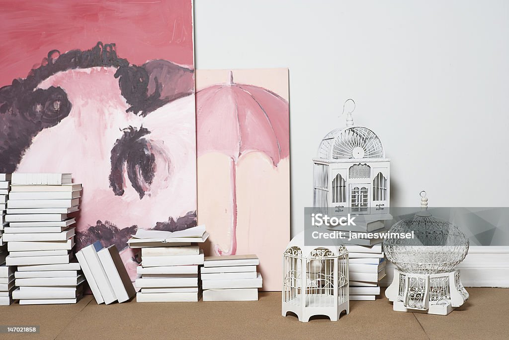 Room decoration Paintings, bird cages, and books line the base of a studio wall. Art Stock Photo
