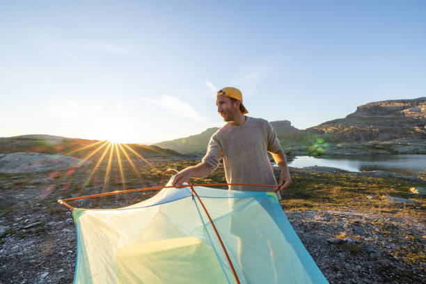 istock Man setting up tent outdoors in Norway 1470220860