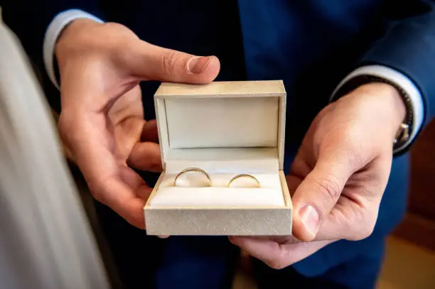 wedding rings and details the groom's witness holds a box with wedding rings in his hands