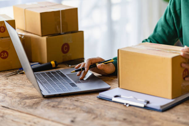 Startup or Small Business Entrepreneur prepare to deliver with parcel box note delivery address from customer, manage orders in online store, internet shopping, SME business concept, e-commerce. stock photo