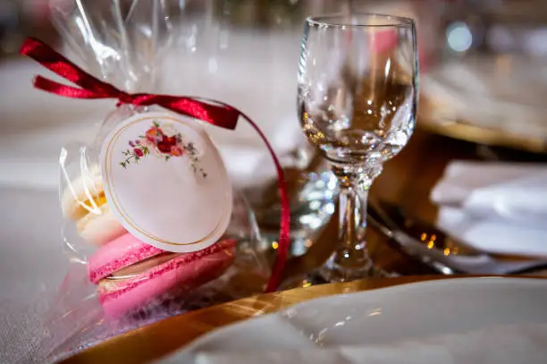 tableware and table decorations at celebrations a gift of macaroons on the table with white tablecloth and glass