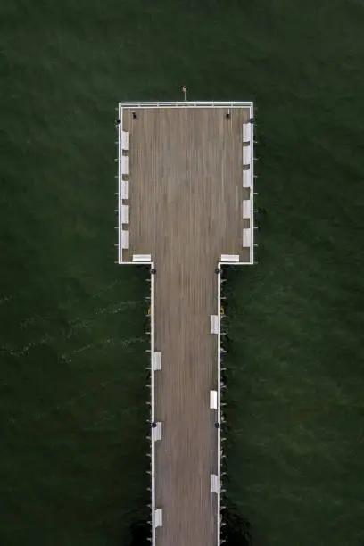 wooden pier on the background of green water, top down view