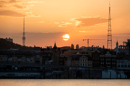 Sunset in Kyiv with a view of Podil downtown district and Dnipro river on the foreground