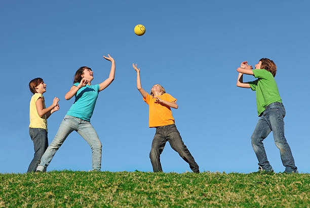 group of kids playing game with ball outdoors at summer camp