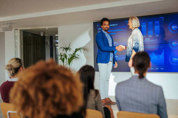 istock Businesspeople shaking hands on stage in conference. 1470229444