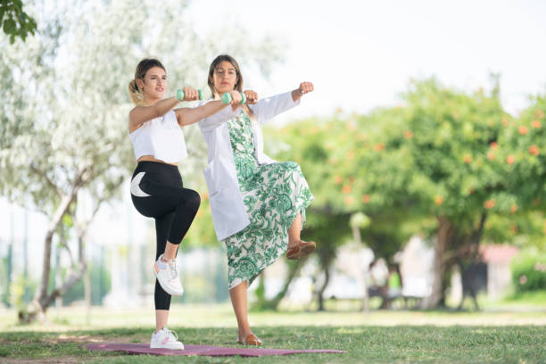 istock Female physiotherapist is examining to her patient under the tree. 1470229837