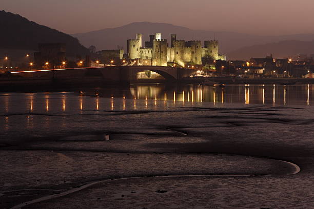 Conwy Castle in Wales at Dusk. Kind Edward I's Conwy Castle in Northern Wales during low tide. Long exposure at sunset conwy castle stock pictures, royalty-free photos & images