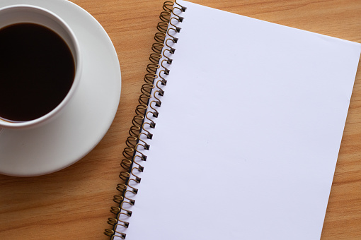 Blank notebook for writing and coffee cup