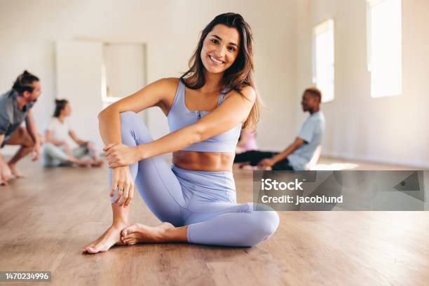 Woman Sitting In A Fitness Studio With Her Yoga Class Stock Photo - Download Image Now