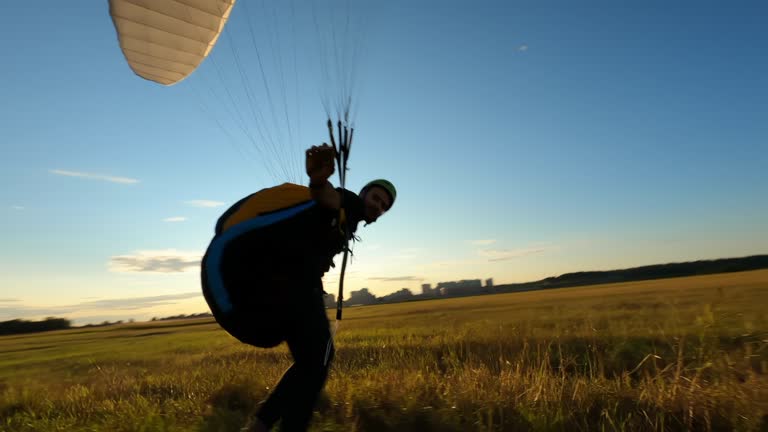 Paraglider flying above the forest, fpv drone flies above his head