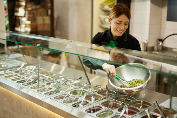 istock Attractive woman working at a salad bar 1470238381