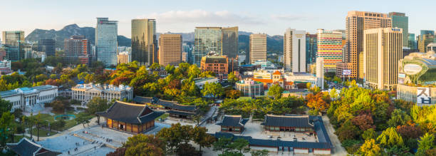 Seoul aerial panorama over downtown skyscrapers cityscape Deoksugung sunset Korea The modern skyscrapers of central Seoul overlooking the tranquil pavilions of Deoksugung in the heart of South Korea’s vibrant capital city. aerial view of seoul south korea capital city stock pictures, royalty-free photos & images
