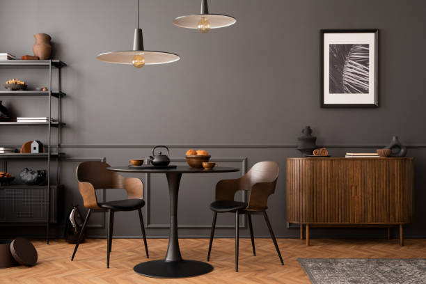 istock Creative composition of living room interior with mock up poster frame, round black table, wooden sideboard, stylish chair, plants, rack, lamp and personal accessories. Home decor. Template. 1470238542