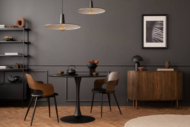 istock Creative composition of living room interior with mock up poster frame, round black table, wooden sideboard, stylish chair, plants, rack, lamp and personal accessories. Home decor. Template. 1470238595