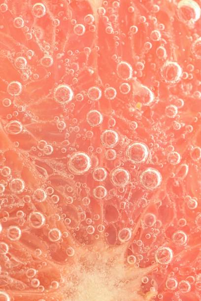 istock Slice of grapefruit in sparkling water. Grapefruit slice covered by bubbles in carbonated water. Grapefruit slice in water with bubbles 1470239749