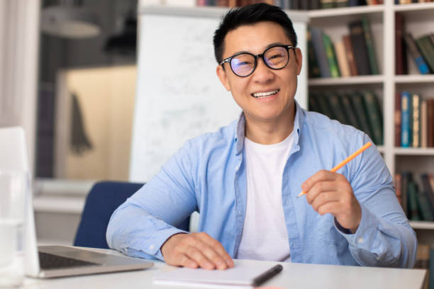 istock Happy Korean Tutor Man Taking Notes Having Online Class Indoor 1470239971