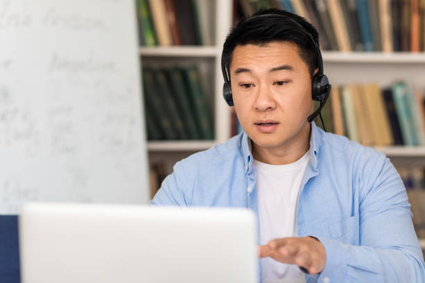 istock Asian Man Making Video Call Talking To Laptop At Workplace 1470240120