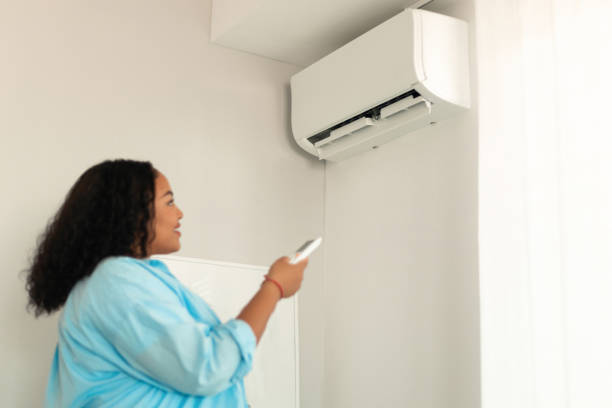 istock African Female Pointing Remote Controller Turning On Air Conditioner Indoor 1470240700