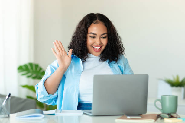 istock Online meeting concept. Happy black body positive lady using laptop for virtual conferencing, having video call at home 1470240928
