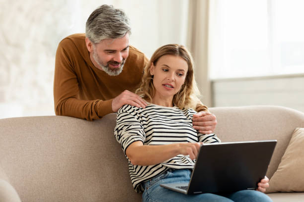 istock Middle Aged Husband And Wife Using Laptop Browsing Internet Indoor 1470240978