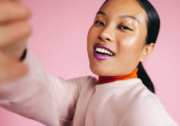 istock Radiant Beauty: Young Asian woman taking a selfie in a studio 1470240987