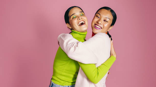 istock Female friends with vibrant makeup up embracing each other in a studio 1470241061