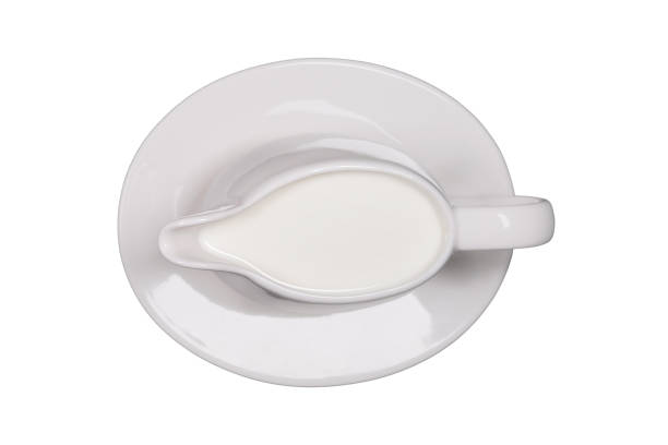 istock White creamer with milk on a saucer, isolated on a white background 1470241333