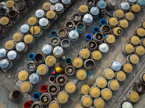 Drone view a working is checking fish sauce brew jars in Mui Ne district, Phan Thiet, Binh Thuan province, central Vietnam