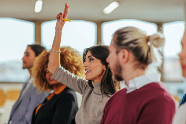 istock Woman holding hand up for question in conference. 1470243105