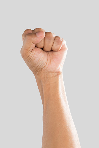 Man's fist on a gray background.