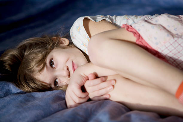 istock Little serious girl lying on bed. 147024628