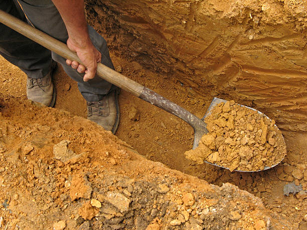 Digging a trench Digging a trench using a shovel ditch stock pictures, royalty-free photos & images