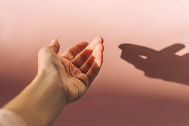 istock Woman's hand on pink background, sunny day. 1470246755