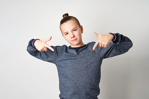 Portrait of teenage boy showing Yo gesture with hands. Boy holding hands like a rapper