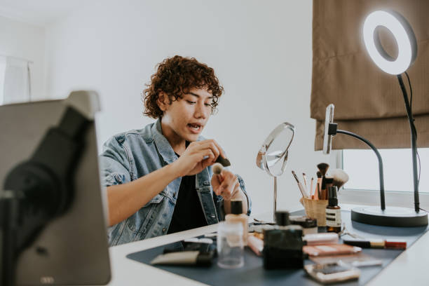 istock Young male artist sharing some technique to applying foundation while live streaming. 1470248673