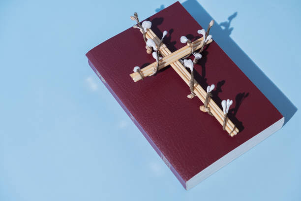 istock Cross decorated flowers with Holy Bible on blue background. Easter holiday minimalistic concept 1470248821