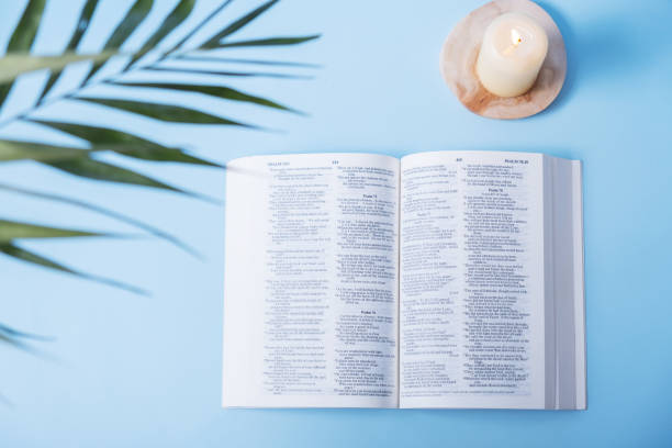 istock Open Holy Bible with andles and palm leaves on blue background 1470248982
