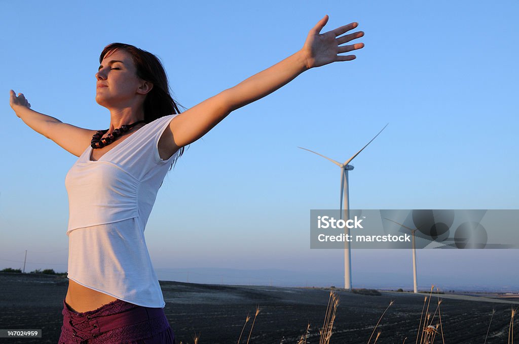 Woman and wind turbines Woman and wind turbines,alternative energy and relax. One Woman Only Stock Photo