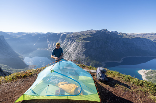Wild camping in the mountains in Norway in summer.\nBeautiful view on the fjord.