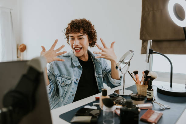 Young gay man as a makeup artist recording makeup tutorial video on his  youtube channel.
