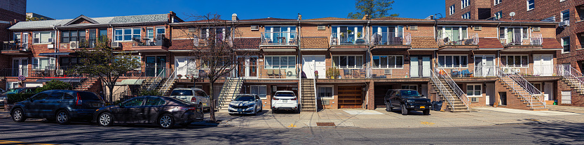 Red Brick Rowhouses on Ridge Blvd. between Marine Ave. and Shore Rd. in Bay Ridge Neighborhood of Brooklyn, New York, USA. Cars and SUVs parked on the driveways and on the Street next to the houses. Canon EOS 6D (full Frame Sensor) Camera and Canon EF 24-105mm F/4L IS lens. High resolution stitched panoramic image. This image was downsized to 50MP. 4:1 Image Aspect Ratio.