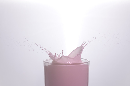 Drop in glass of pink milk