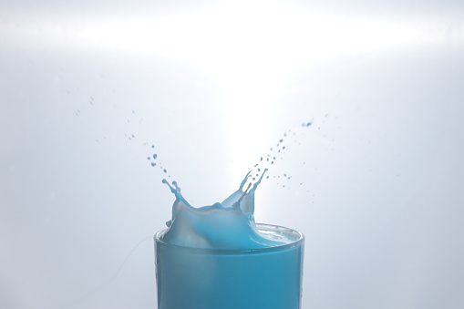 Drop in glass of blue milk