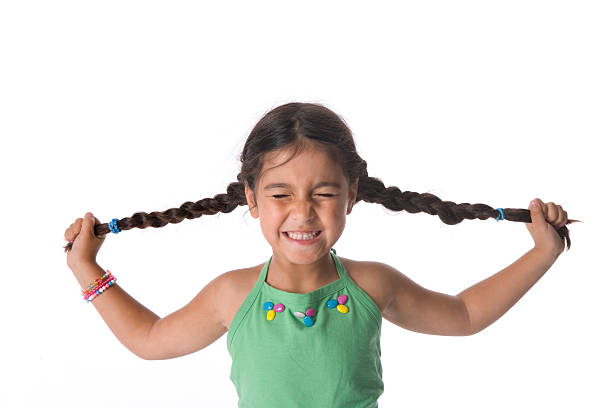 маленькая девочка, потянув ее хвосты - anger child braids braided стоковые фото и изображения