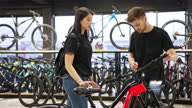 istock Salesman and female customer in bicycle shop 1470257034