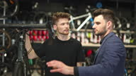 istock Salesman and male customer in bicycle shop 1470257046