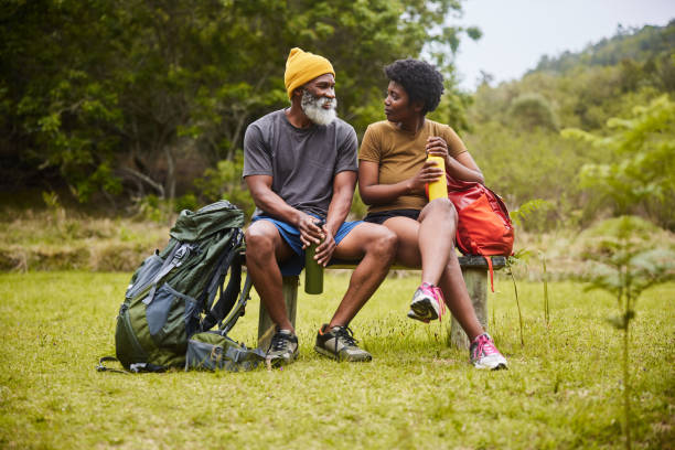 istock Couple sitting on a bench and drinking water during a hike 1470260068