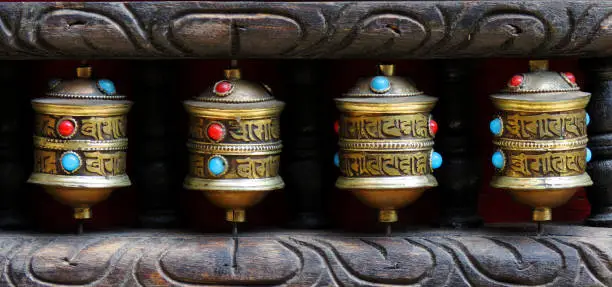 Photo of Buddhist prayer wheels in Nepal. Prayer wheels are spun by devotees to aid for meditation and accumulating wisdom, good karma and putting negative energy aside. Praise to the Jewel in the Lotus.