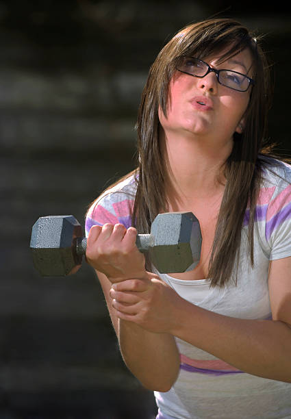 Teen girl plays with weight stock photo