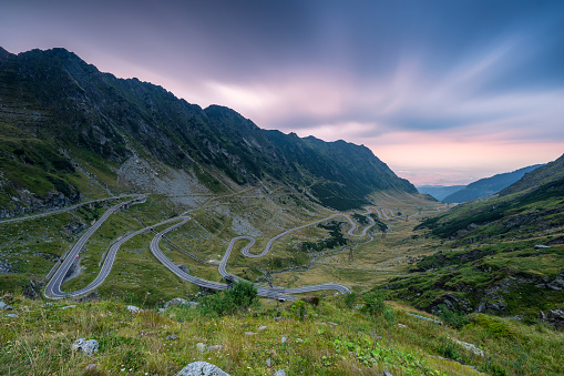 Amazing sunset view with colorful clouds of the north part of famous Transfagarasan serpentine mountain road between Transylvania and Muntenia in Romania.